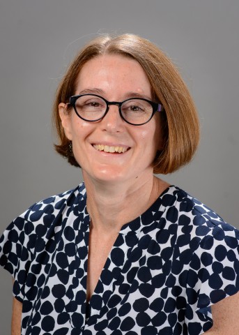 Photograph of Dr. Pavao-Zuckerman. She is wearing a blue and white polka-dot shirt, and has light-colored skin, chin-length brown hair, and glasses.