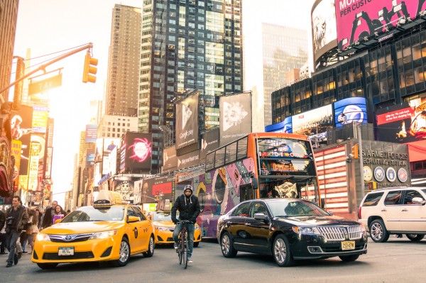 Downtown city street with cars, pedestrians, and bicyclists